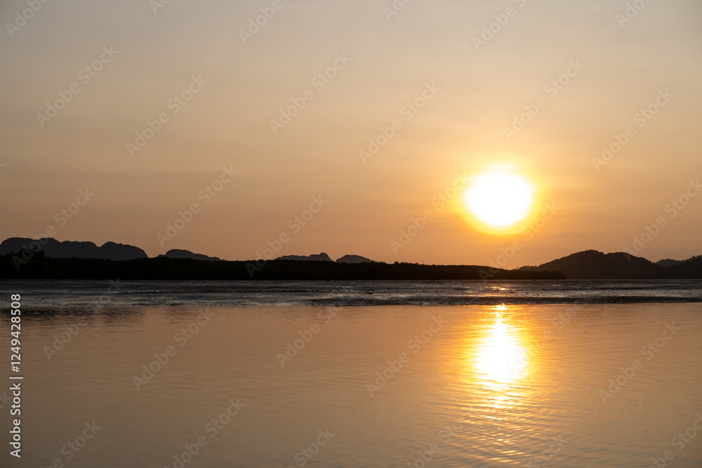 Sunrise view with colorful sky and the sea, with silhouette of the forest on the background Sunrise view with colorful sky and the sea, with silhouette of the forest on the background