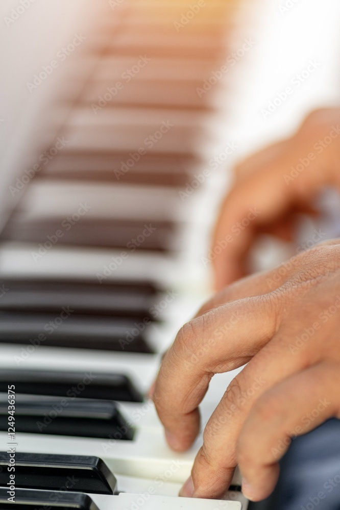 Obraz premium Close-up of hands playing piano keys with focus on fingers and musical expression