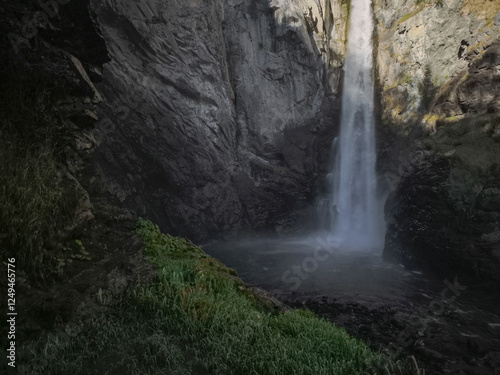 Powerful waterfall flowing over rocky terrain, surrounded by autumn foliage in valle d'aosta mountain landscape during late fall season Isollaz waterfall photo