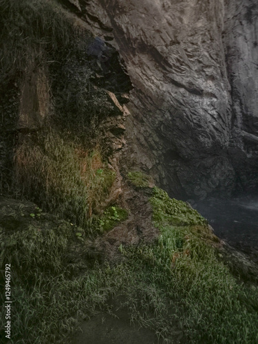 Rocky cliffs near aosta embracing verdant foliage, highlighting alpine landscape's lush greenery during late autumn's peaceful moments Isollaz waterfall