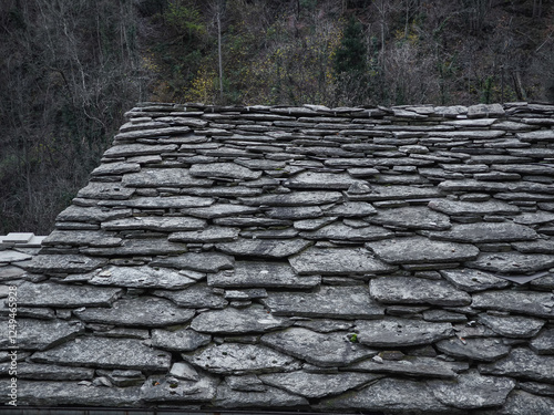 Weathered stone roof texture contrasting autumnal foliage in aosta valley, highlighting traditional mountain architectural elements pontboset photo