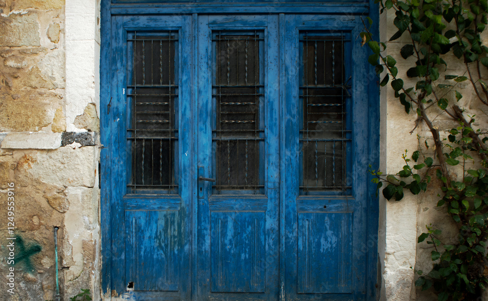 Rustic blue wooden bi-fold doors in Greece - Closeup Rustic blue wooden bi-fold doors in Greece - Closeup