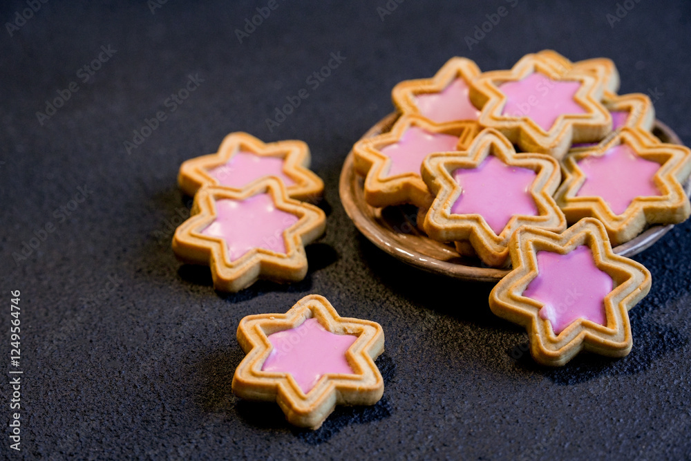 Homemade sweets in the shape of a star, cookies in the shape of a star on a black background. Selective focus. A plate with gingerbread in the shape of a star, top view, horizontal. Homemade sweets in the shape of a star, cookies in the shape of a star on a black background. Selective focus. A plate with gingerbread in the shape of a star, top view, horizontal.