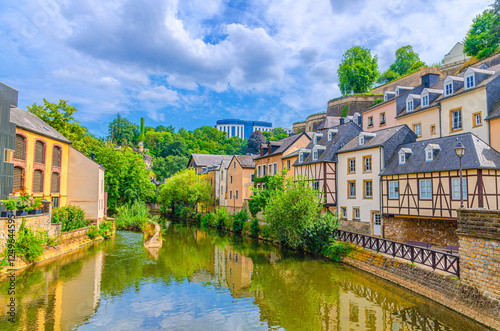 Grund quarter in Luxembourg City historical centre with old typical buildings, green trees and bushes on bank of Alzette river valley in old town Gronn lower city in summer day photo