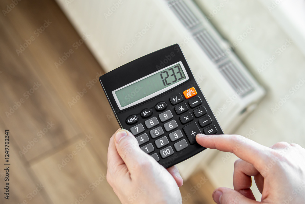 Man counts on a calculator. Natural. Big heating bill Man counts on a calculator. Natural. Big heating bill