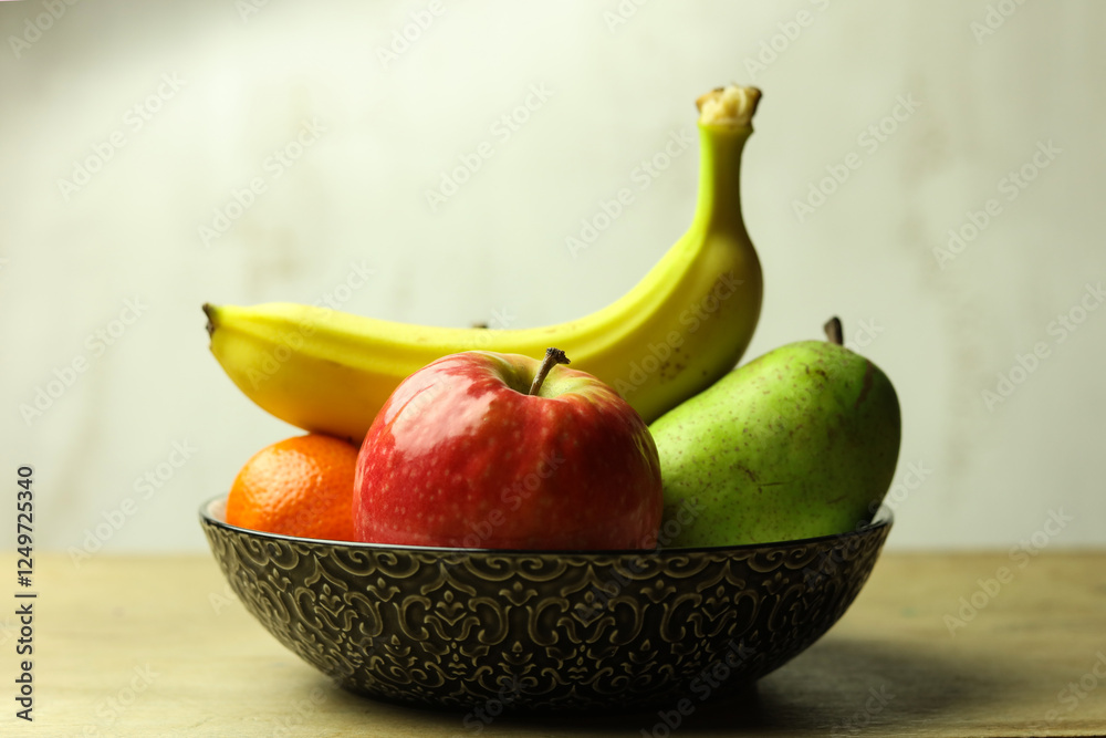 Still life of fresh fruits in a bowl on wooden table, selective focus Still life of fresh fruits in a bowl on wooden table, selective focus