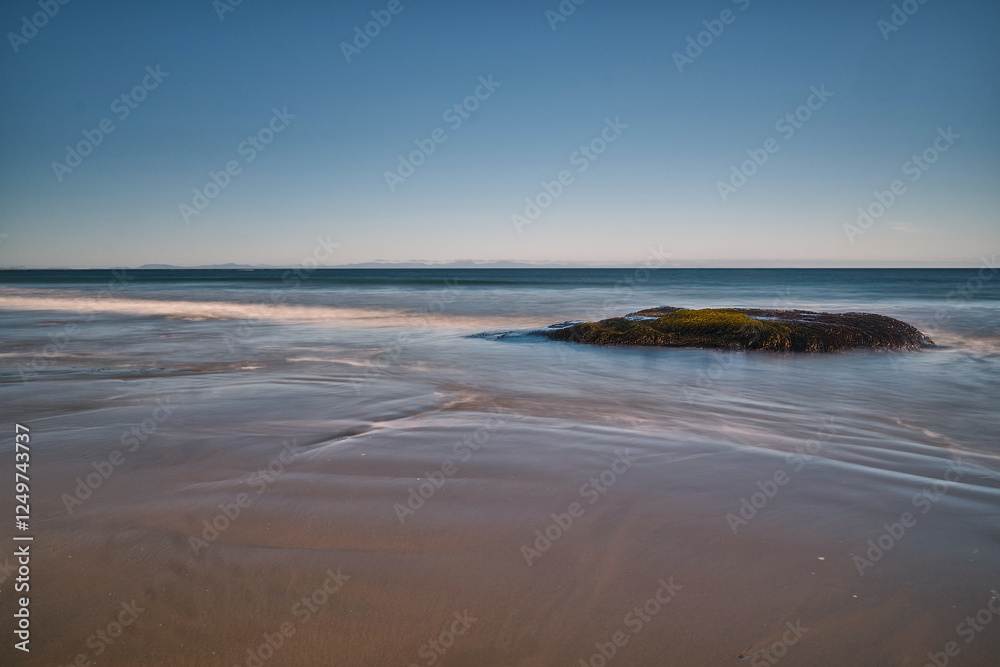 The image captures a serene, ethereal seascape bathed in a soft, dreamy light. Smooth, flowing waves gently undulate across the frame. The image captures a serene, ethereal seascape bathed in a soft, dreamy light. Smooth, flowing waves gently undulate across the frame.