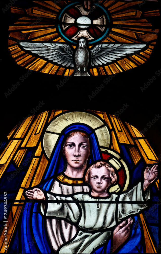 Fototapeta premium Stained glass (19th century) of Blessed Virgin Mary holding baby Jesus Christ in her arms with the Holy Spirit.