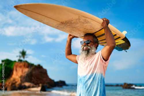 Canvas Print Senior black man with surfboard on sunny ocean beach holds board overhead