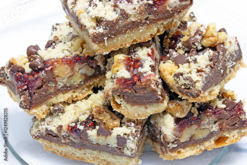 Bittersweet dark chocolate raspberry dessert bars with chopped walnuts on bottom layer of butter, flour and brown sugar photo