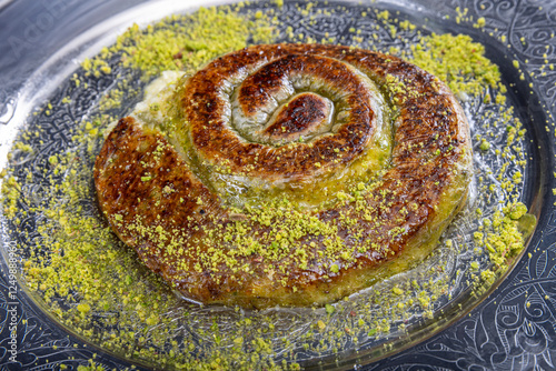 Traditional Turkish Dessert Katmer, clotted cream, dough, katmer dessert of Turkey Gaziantep region. Prepared with thin dough dessert with ice cream and green pistachio. photo