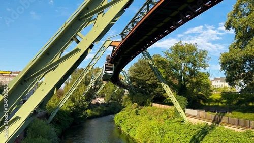 Train car moves on monorail suspended on overpass of Wuppertal Suspension Railway. Public transport metropolitan in Wuppertal, North Rhine Westphalia, Germany July 29, 2024. High quality 4k footage