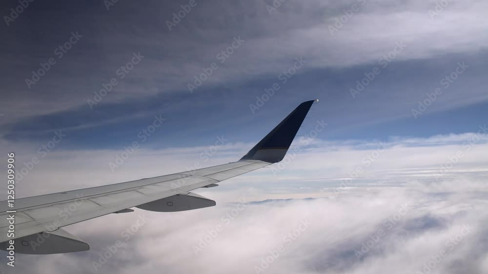 Flying Between the Clouds Looking Over a wing of a plane Flying Between the Clouds Looking Over a wing of a plane