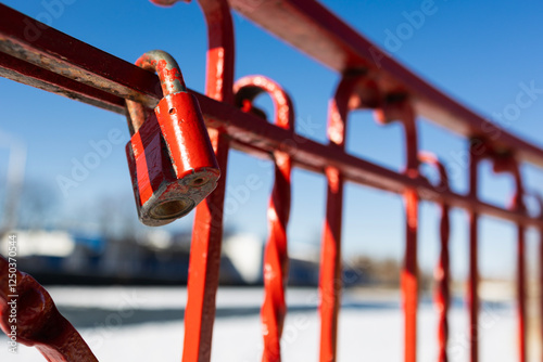 Old red padlock on metak fence . Copy space photo