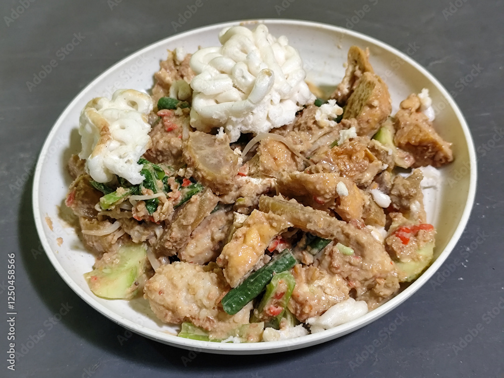Rujak Cingur. Traditional Javanese food consisting of lontong with vegetables, peanut sauce, petis, tempeh, tofu, beef tongue, and crackers. Rujak Cingur. Traditional Javanese food consisting of lontong with vegetables, peanut sauce, petis, tempeh, tofu, beef tongue, and crackers.