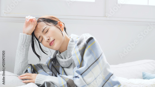 女性、発熱、疲労、風邪、かぜ、冬、日本人、インフルエンザ、寒い、寒暖差、咳き込む、冷え性、室内、リビングルーム、体調不良、疲れ、ダウン、ストール、防寒、エアコン、暖房、アレルギー、交感神経、自律神経、ストレス、困る、悩む、悩み、ブランケット、毛布、対策、休む、つらい、落ち込む、がっかり、頭痛、コロナ、ライノウイルス、RSウイルス、寒気、悪寒、溶連菌、冬風邪、倦怠感、寝込む、病気、休養、不安、バテる photo