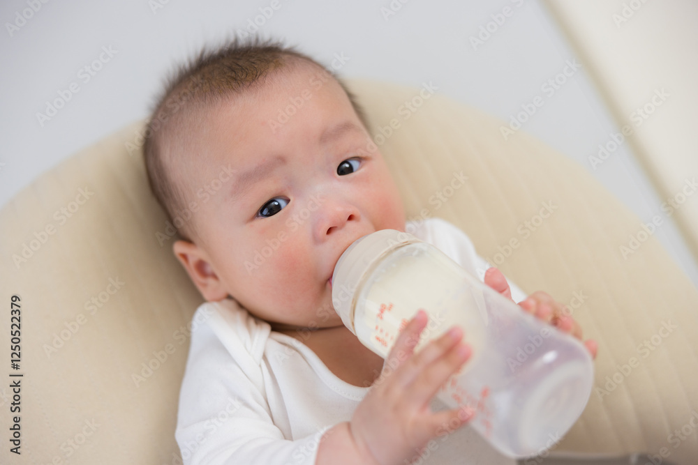 Adorable baby enjoying fresh milk bottle indoors Adorable baby enjoying fresh milk bottle indoors