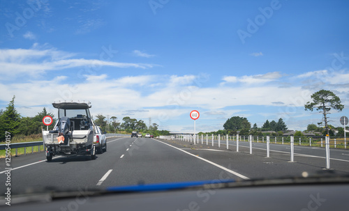 Obraz na płótnie Car towing a boat on Waikato Expressway. 110 kmh road speed signs by the side of highway. New Zealand. w salonie