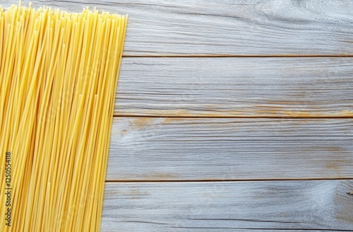 Uncooked spaghetti on a light wood table top photo