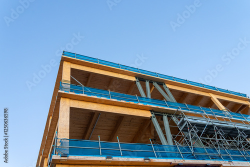 Under construction a large wooden and steel framed building from street level.