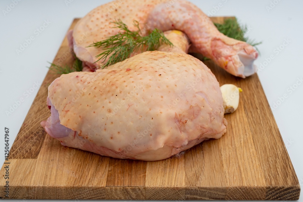 Fresh raw chicken legs with dill and garlic on a wooden board. Fresh raw chicken legs with dill and garlic on a wooden board.