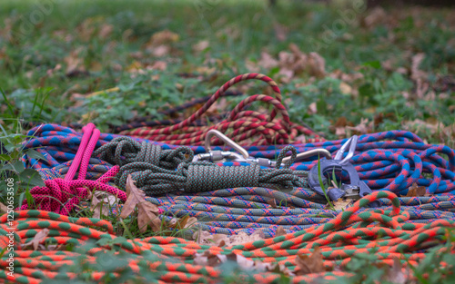 Rope in coils, carabiners, jumars and other equipment for sports tourism on the ground in the park, view from above photo