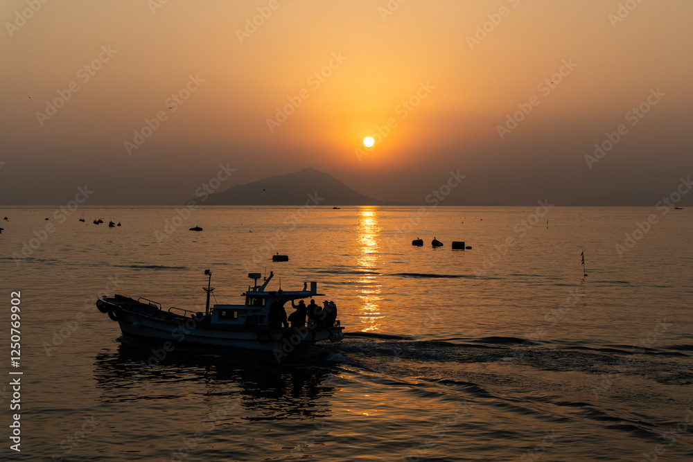Naklejka premium fishing boat on the sea during sunrise