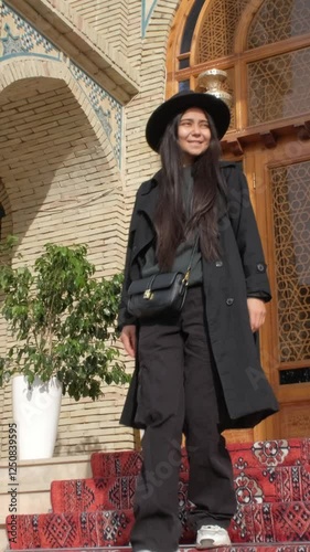 A young woman stands gracefully walking an oriental setting