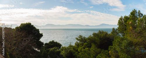 A picturesque path among pine trees in the background and a view of the islands of Croatia. Panorama