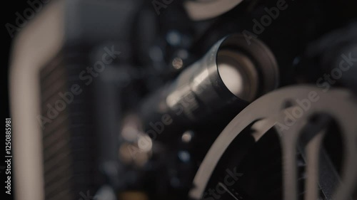 Close ups of a vintage 8MM projector spools moving and playing film 