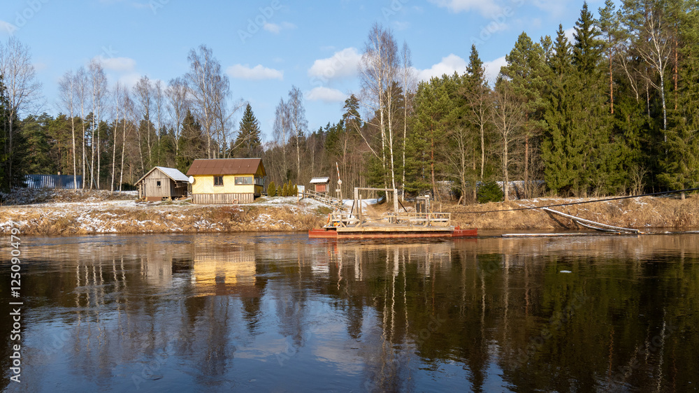 Obraz premium Rustic Wooden Cable Ferry Crossing a River in Winter. 07.02.2025. Ligatne. Latvia.