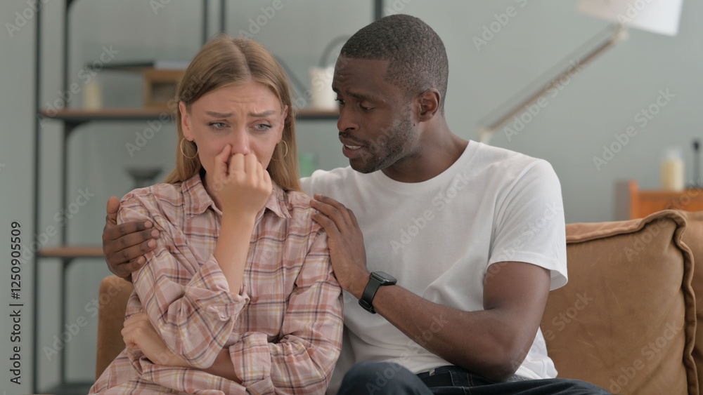 Obraz premium African Man Consoling Depressed Crying Wife at Home