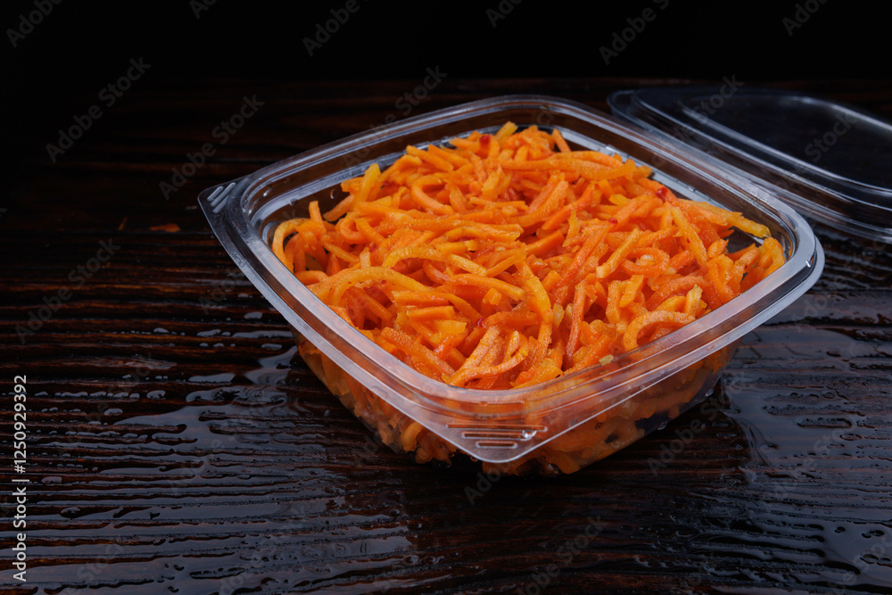 Koreyskiy salat iz ostroy morkovi v plastikovom konteynere .