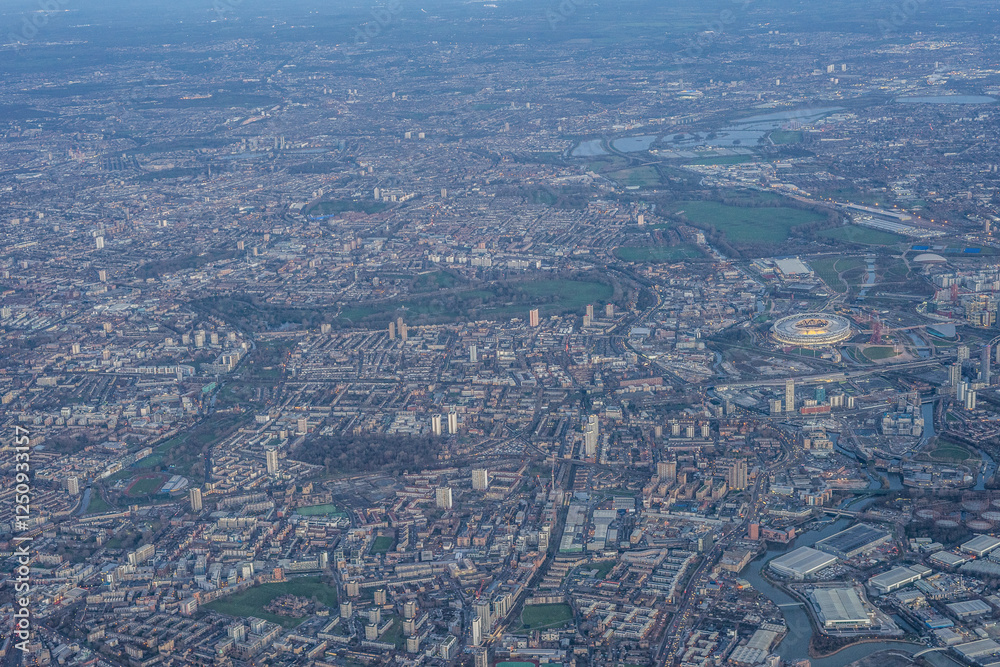 Aerial view of London through early morning clouds with Thames river flowing at golden hour sunrise near Tower Bridge