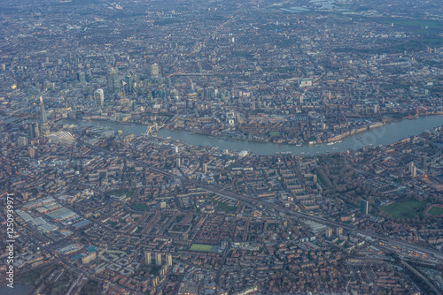 Obraz na płótnie Aerial view of London through early morning clouds with Thames river flowing at golden hour sunrise near Tower Bridge w salonie