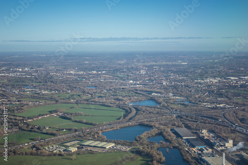 Obraz na płótnie Aerial view of London outskirts suburbs through early morning clouds with Thames river flowing at golden hour sunrise near industrial area w salonie