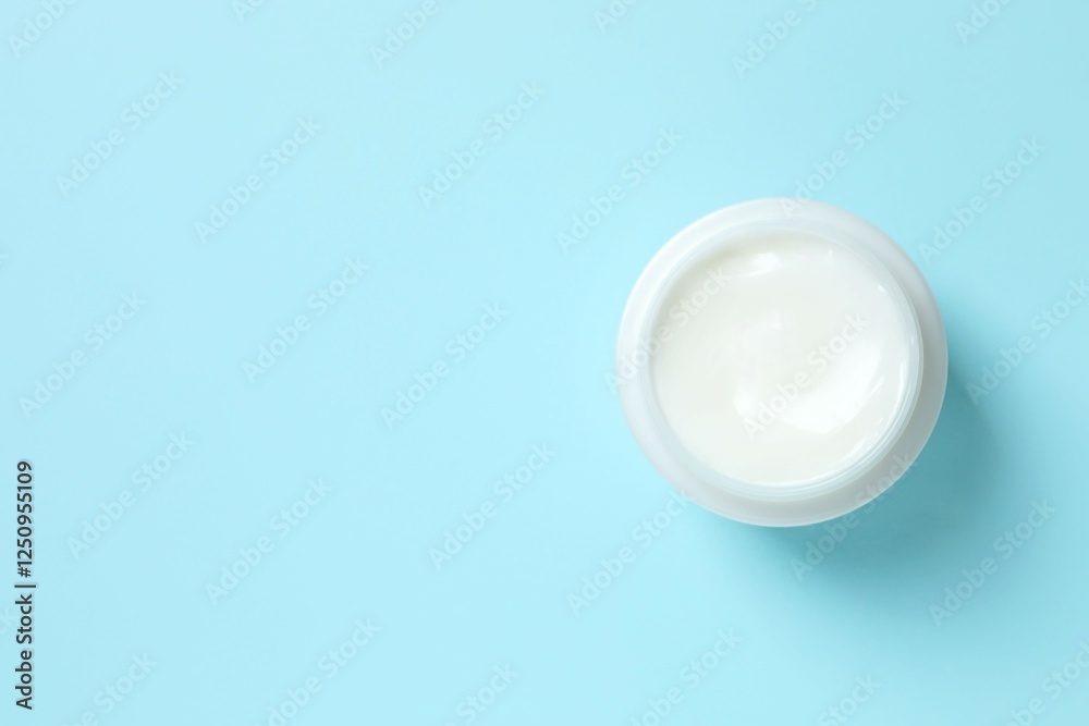 Cosmetic jar with moisturizing cream. Natural cosmetic products on a blue background, top view Cosmetic jar with moisturizing cream. Natural cosmetic products on a blue background, top view