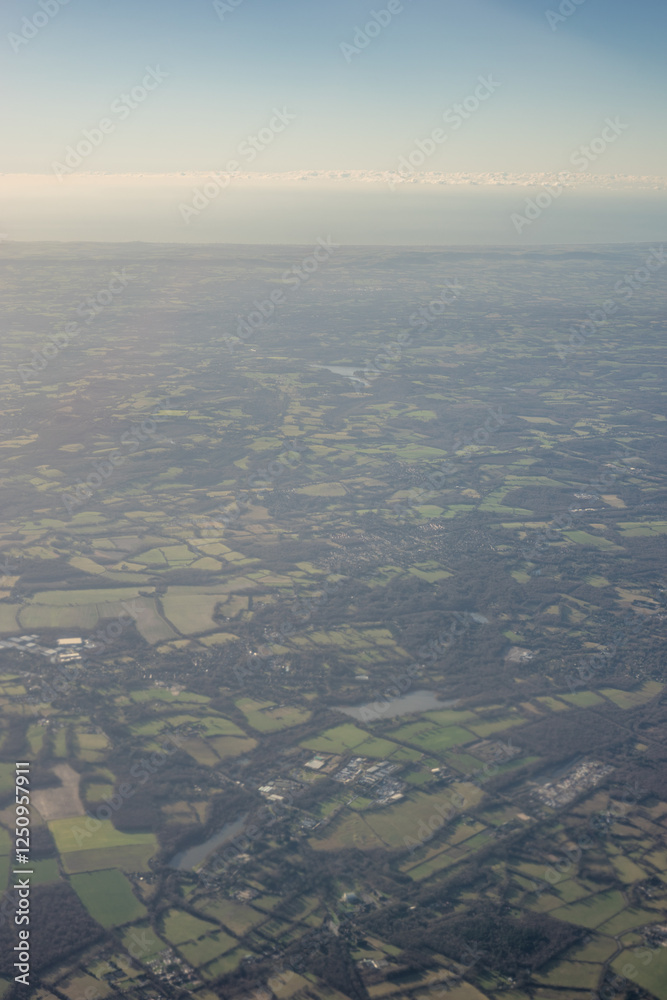 Aerial view of London outskirts lush green fields from an aeroplane window