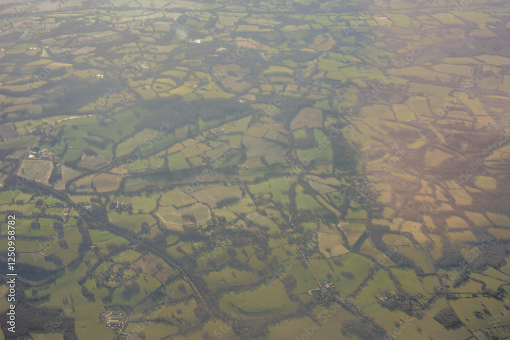 Aerial view of London outskirts lush green fields from an aeroplane window