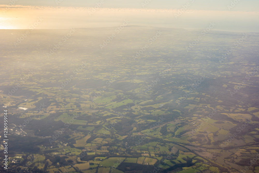 Aerial view of London outskirts lush green fields from an aeroplane window