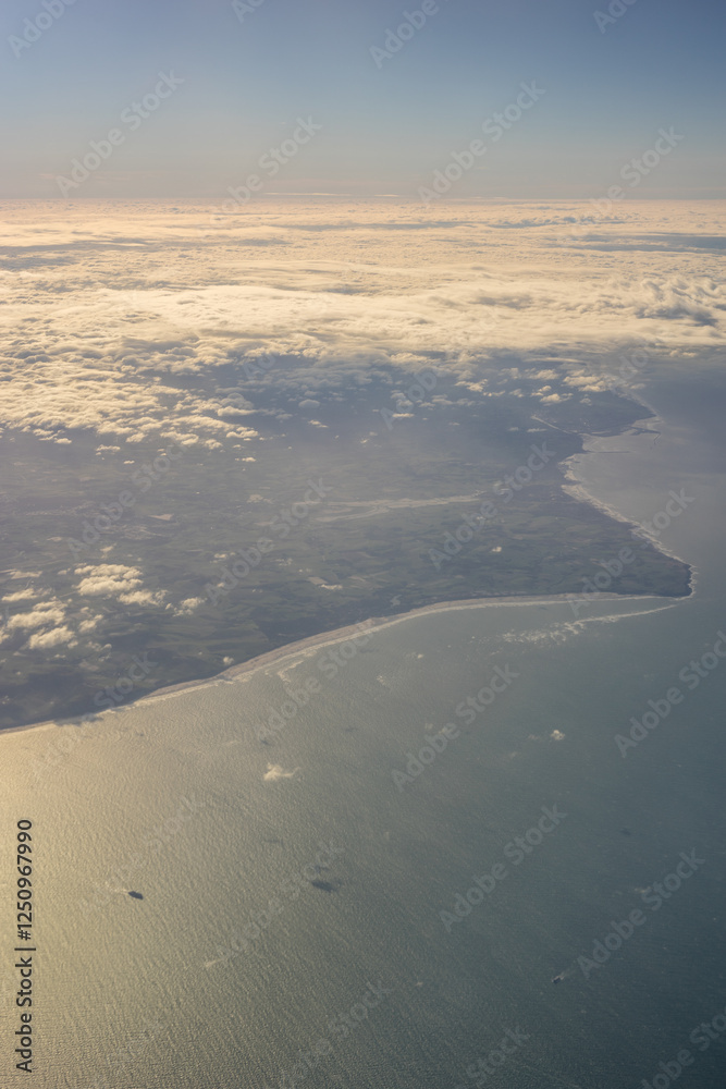 London, United Kingdom, England, a view of the ocean from an aeroplane window with clouds in the sky