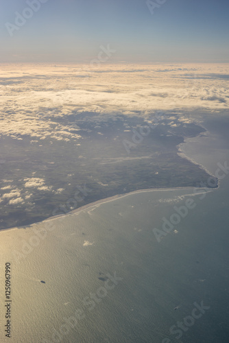 Obraz na płótnie London, United Kingdom, England, a view of the ocean from an aeroplane window with clouds in the sky w salonie