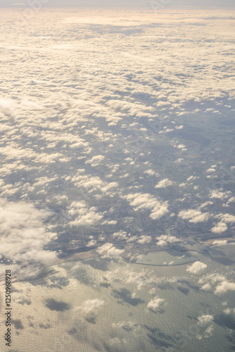 Obraz na płótnie London, United Kingdom, England, a view of the ocean from an aeroplane window with clouds in the sky w salonie