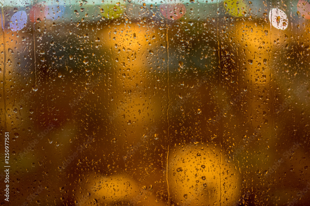 water drops on flass with lights in the background