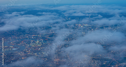 Obraz na płótnie Aerial view of London through early morning clouds with Thames river flowing at golden hour sunrise w salonie