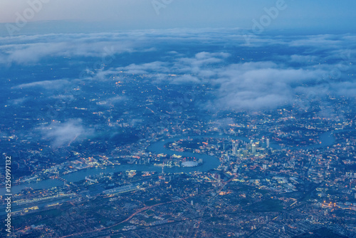 Obraz na płótnie Aerial view of London through early morning clouds with Thames river flowing at golden hour sunrise w salonie