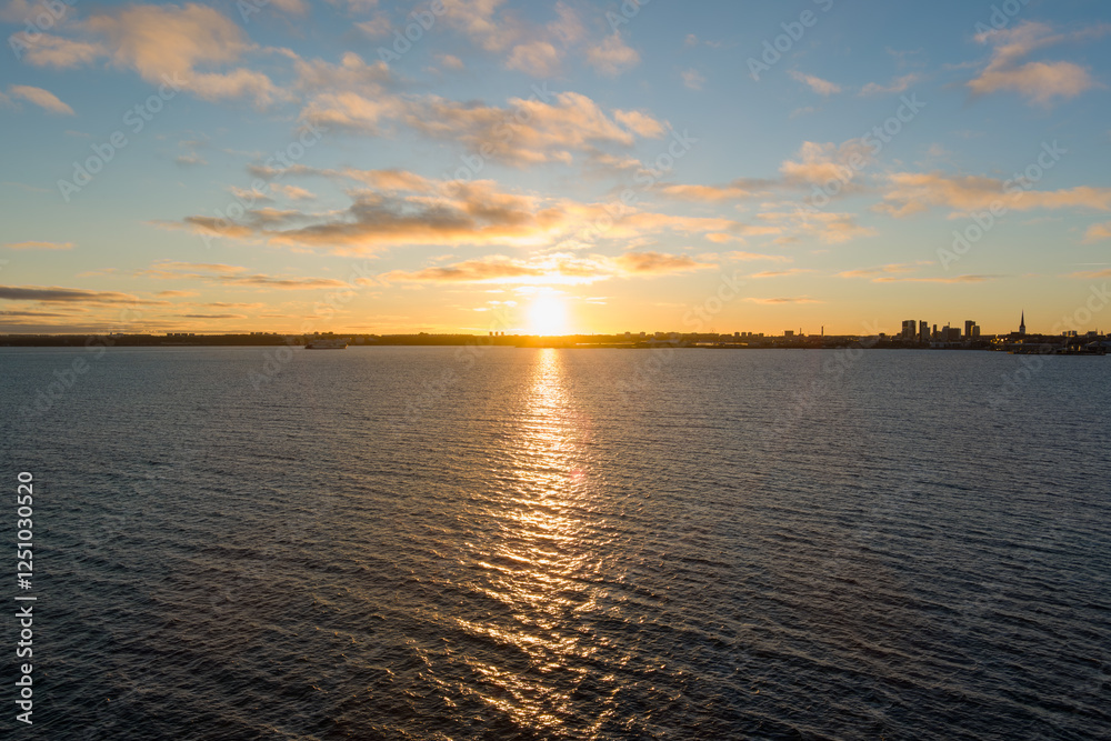 Fototapeta premium Tallinn Awakens: Aerial cityscape panorama of Tallinn, Estonia, bathed in the warm glow of sunrise over the bay.