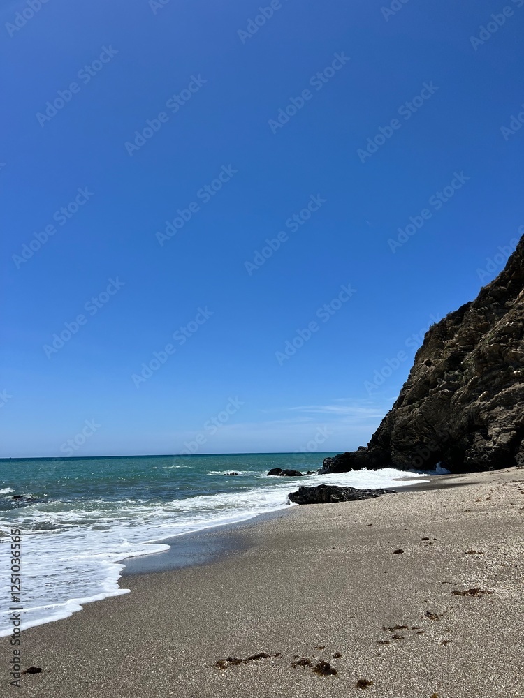 Tranquil Beach with Clear Blue Sky and Waves Tranquil Beach with Clear Blue Sky and Waves