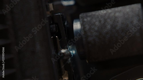 Close ups of a vintage 8MM projector spools moving and playing film 