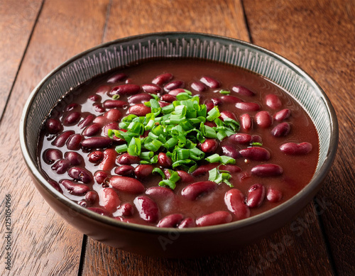 red bean soup with a sprinkle of chopped scallions on a wooden table texture beans photo